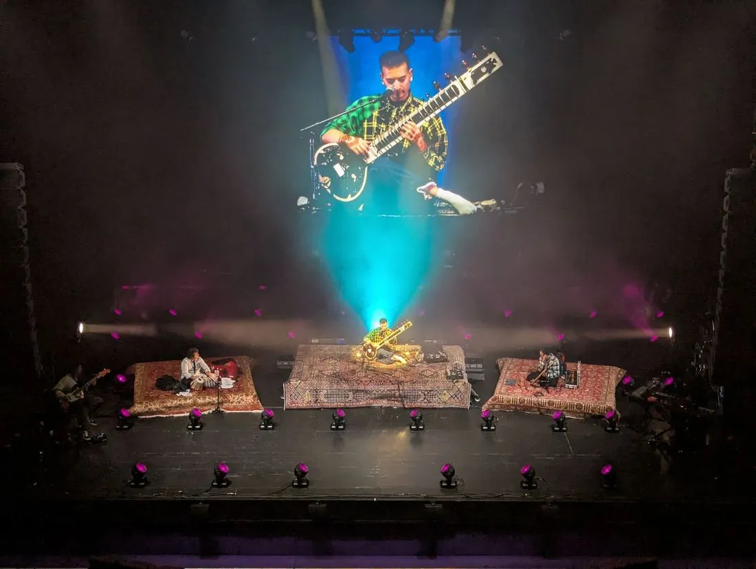 Overhead view of Rishab's stage set of rug-covered risers with the IMAG screen above